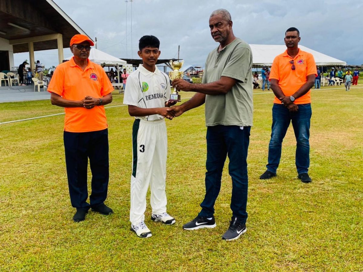 Man of the Match, Darwin LaRose of Demerara Under-15 receives his award from former Test bowler, Clyde Butts
