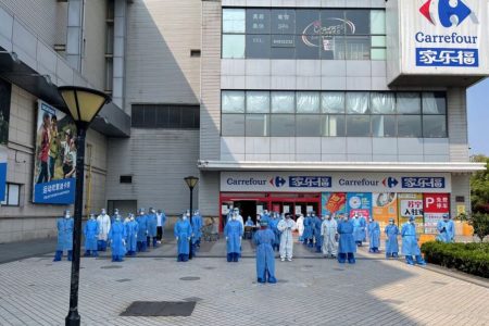 Staff members in protective suits gather at the Xujing branch of Carrefour hypermarket, following the coronavirus disease (COVID-19) outbreak in Shanghai, China, in this undated handout picture provided to Reuters April 20, 2022. Lu Sunping/Carrefour/Handout via REUTERS