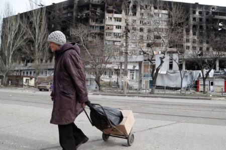 An elderly woman crosses a street in Mariupol (Reuters photo)