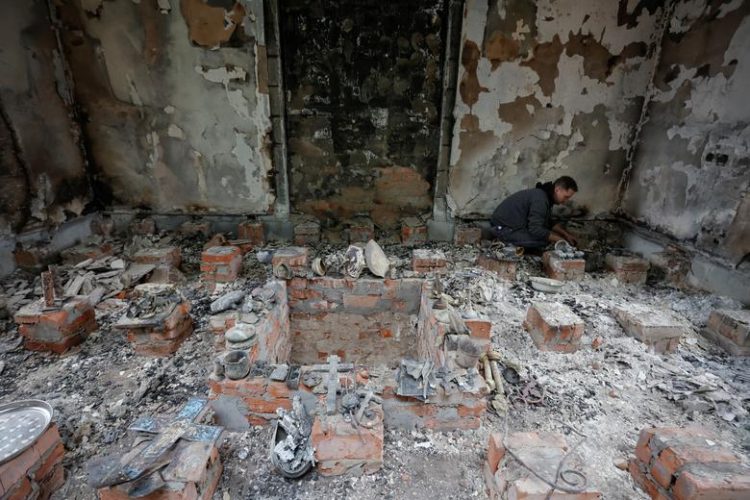 A believer removes debris inside a church building damaged by heavy shelling, as Russia's attack on Ukraine continues, in Chernihiv, Ukraine April 6.  REUTERS/Serhii Nuzhnenko