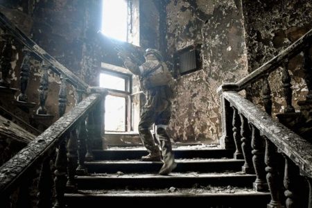 A Russian soldier climbs stairs at the Mariupol drama theatre, hit on March 16 by an airstrike, on April 12, 2022 in Mariupol. (AFP)