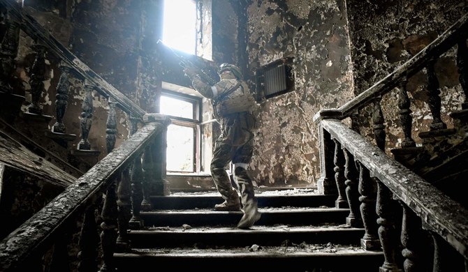 A Russian soldier climbs stairs at the Mariupol drama theatre, hit on March 16 by an airstrike, on April 12, 2022 in Mariupol. (AFP)