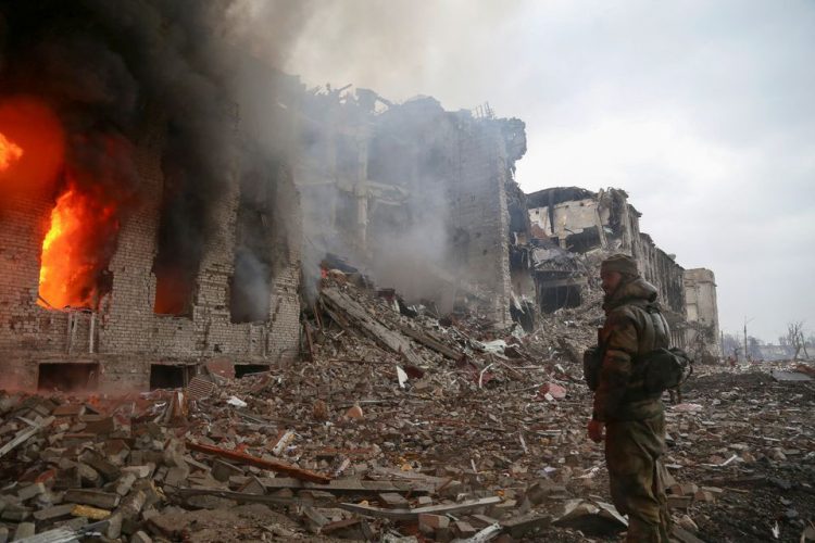 A service member of pro-Russian troops stands in front of the destroyed administration building of Azovstal Iron and Steel Works during Ukraine-Russia conflict in the southern port city of Mariupol, Ukraine April 21, 2022. REUTERS/Chingis Kondarov