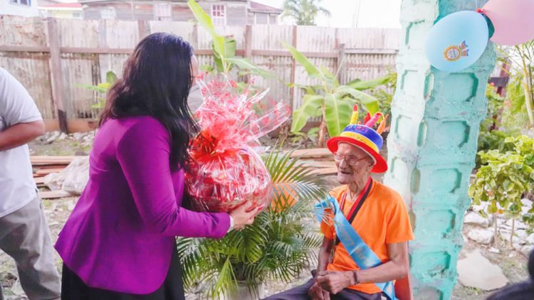 Minister of Human Services and Social Security,  Dr. Vindhya Persaud presenting a hamper to  Hilton ‘Champ’ Lewis (Ministry of Human Services and Social Security photo)