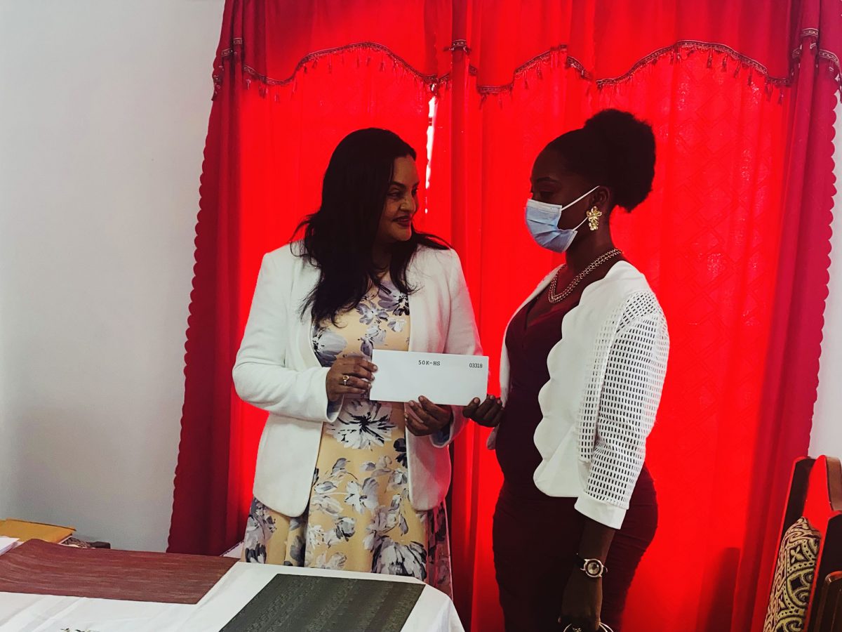 Minister Vindhya Persaud handing over one of the grant to a recipient. 