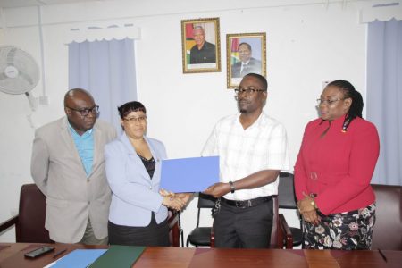 Ministry of Education Permanent Secretary (ag) Adele Clarke (second from left) shakes hands with GTU President Mark Lyte after the signing of the agreement on the MoU and other matters on October 24 2018.  Chief Education Officer Marcel Hutson (left) and GTU General Secretary Coretta McDonald look on. (SN file photo)