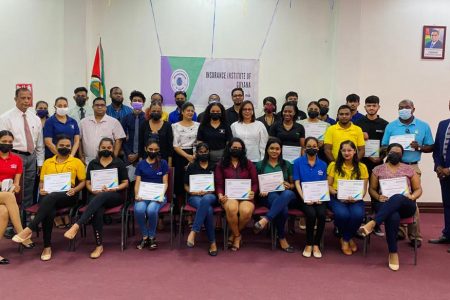 Photo shows the participants with their certificates flanked by Bish Panday (left) and Raymond McMillan.