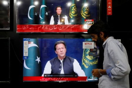 FILE PHOTO: A shopkeeper tunes a television screen to watch the speech of Pakistani Prime Minister Imran Khan, at his shop in Islamabad, Pakistan, March 31, 2022. REUTERS/Akhtar Soomro