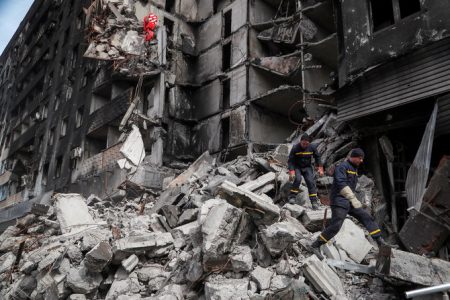Emergency workers remove debris of a building destroyed in the course of the Ukraine-Russia conflict, in the southern port city of Mariupol, Ukraine April 10, 2022. (Reuters)