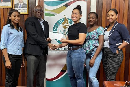 National hockey stalwart Gabriella Xavier receives the National Sports Commission’s donation for the CAC Qualifiers from Director of Sport, Steve Ninvalle, in the presence of her teammates.