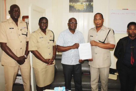 Deputy Commissioner ‘Administration’, Calvin Brutus (second from right) and GITC’s Administrator, Dexter Cornette (third from left) pose with the Memorandum of Agreement. Also in the photo are Force Training Officer, Keithon King (left); Head of the Strategic Planning Unit, Woman Assistant Superintendent of Police, Nicola Kendall (second from left) and Police Legal Advisor, Mandel Moore (right). (Police photo)