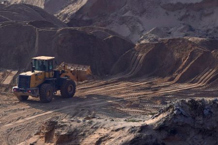 A worker operates a front loader in an area cleared for sand mining on a dried lake bed of Poyang Lake in Jiujiang, Jiangxi province, China December 11, 2019. REUTERS/Aly Song/File Photo