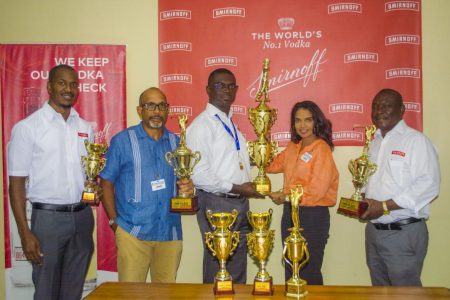 Gavin Todd presents the first place trophy to Anasha Ally while Chet Bowling, Ian Charles and Troy Peters display some of the other trophies up for grabs