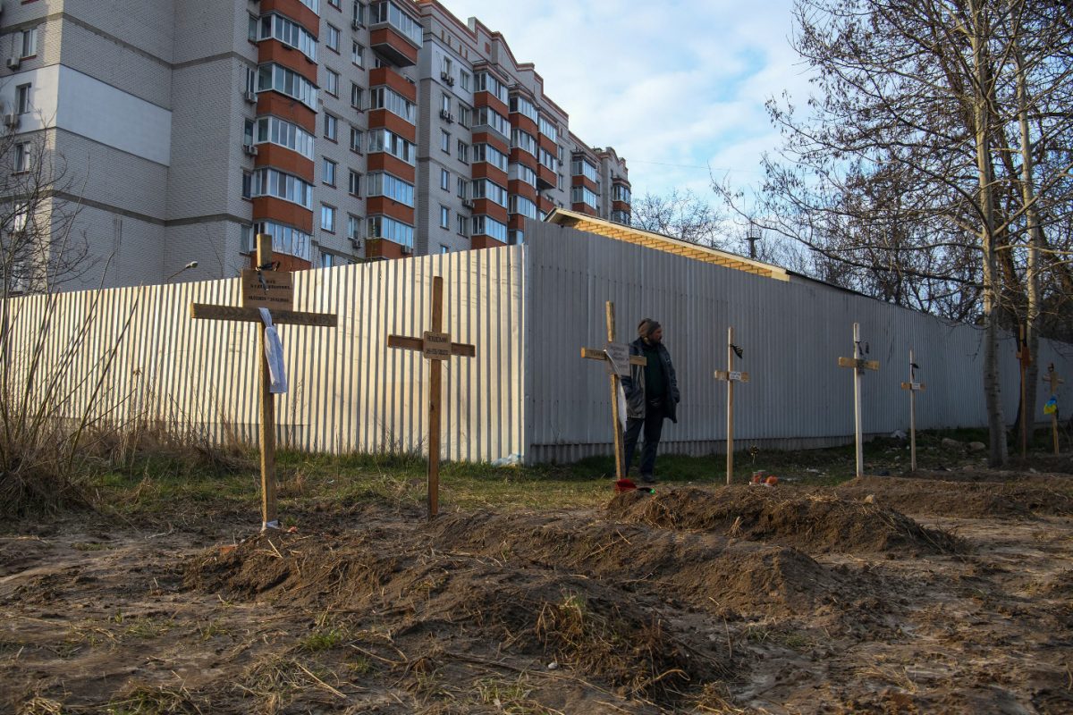 A man stands next to graves with bodies of civilians, who according to local residents were killed by Russian soldiers, as Russia’s attack on Ukraine continues, in Bucha, in Kyiv region, Ukraine April 4, 2022. REUTERS/Vladyslav Musiienko