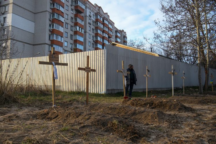 A man stands next to graves with bodies of civilians, who according to local residents were killed by Russian soldiers, as Russia’s attack on Ukraine continues, in Bucha, in Kyiv region, Ukraine April 4, 2022. REUTERS/Vladyslav Musiienko