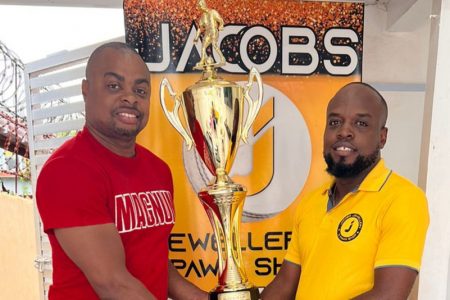 Jacob’s Jewellery Sales Representative, Jamel Semple (right), hands over the second-place trophy to tournament organiser Edison Jefford 