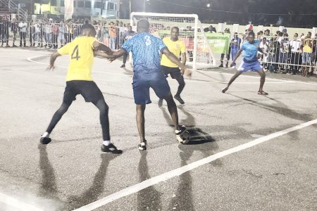 Carl Tudor (blue) of North East La Penitence trying to shield the ball away from a BV player during their clash in the Magnum Independence Cup