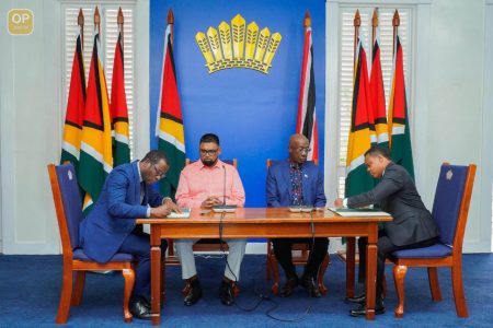 Signing on: Guyana foreign Affairs Minister Hugh Todd and his Trinidad and Tobago counterpart Amery Browne sign the MOU in the presence of President Ali and Prime Minister Rowley 