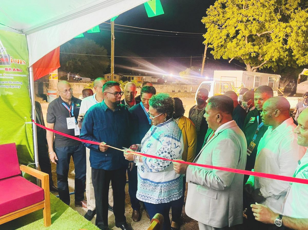 President Irfaan Ali helps Barbados Prime Minister Mia Mottley to cut the ceremonial ribbon in front of the Guyana pavilion to declare open the Barbados Agriculture Festival. The ceremony was witnessed by Minister of Agriculture Zulfikar Mustapha and members of Guyana’s private sector (GMSA photo)