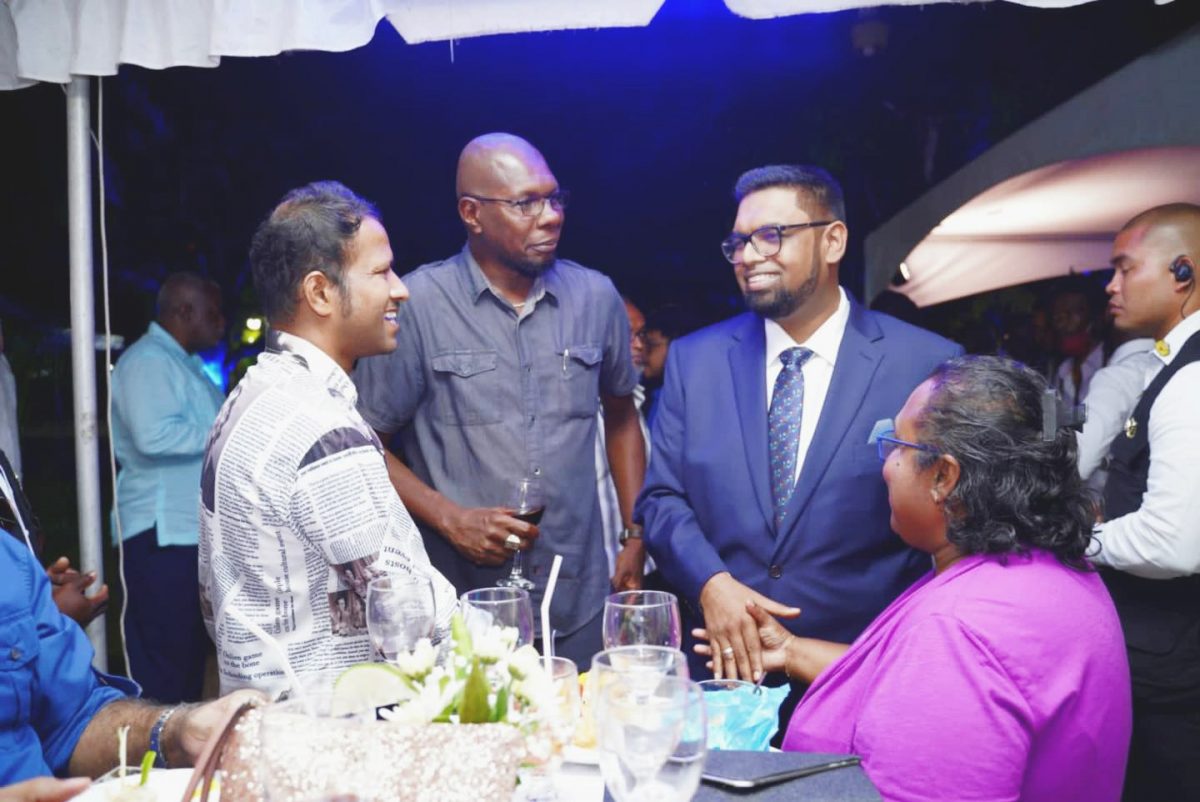 President Irfaan Ali (second from right) with media personnel at a reception that was held at Castellani House on Wednesday for those who attended the symposium. (Office of the President photo)