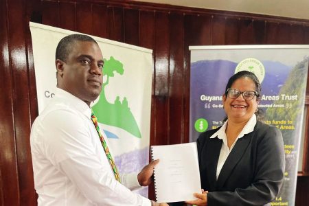 From left: Chair of Guyana Protected Areas Trust Board of Trustees,  Curtis Bernard holds the signed agreement with Chief Executive Officer of the Caribbean Biodiversity Fund,  Karen McDonald Gayle.