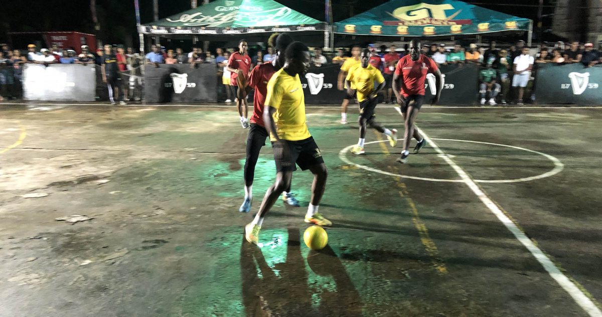 Colwyn Drakes (yellow) of Swag Entertainment in the process of attempting a pass while being challenged for possession by a Darkside player in the Guinness ‘Greatest of the Streets’ Linden edition between at the SilverCity Hard-Court.
