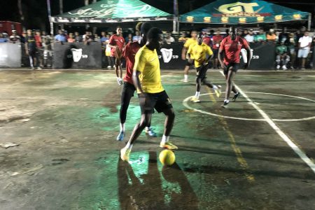 Colwyn Drakes (yellow) of Swag Entertainment in the process of attempting a pass while being challenged for possession by a Darkside player in the Guinness ‘Greatest of the Streets’ Linden edition between at the SilverCity Hard-Court.