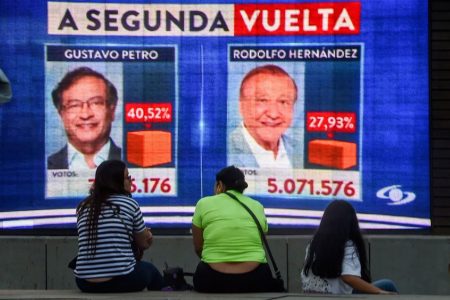 People watch electoral results on a screen during the Colombian presidential election in Medellín on Sunday. (Joaquín Sarmiento/AFP/Getty Images)