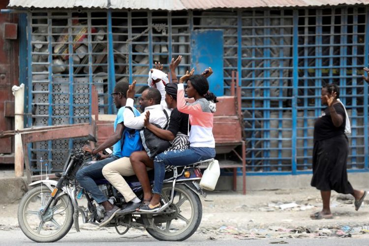 Residents raise their arms as they flee their homes due to ongoing gun battles between rival gangs, in Port-au-Prince, Haiti May 2, 2022. REUTERS/Ralph Tedy Erol