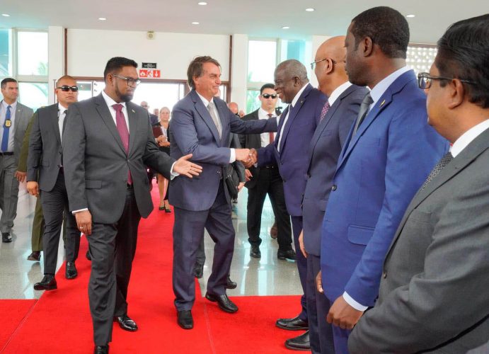 Brazilian President Jair Bolsonaro (centre) being introduced by President Irfaan Ali (left) to Prime Minister Mark Phillips at the Arthur Chung Conference Centre yesterday. (Office of the President photo)