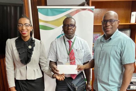 NSC Commissioner, Cristy Campbell (first from left), along with Director of Sport, Steve Ninvalle, handing over the Commission’s $1.8M cheque to president of the GCF, Linden Dowrich (centre).
