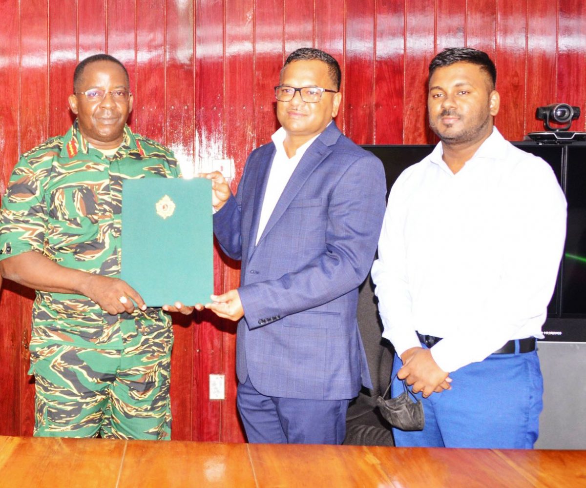 GDF Chief of Staff, Brigadier Godfrey Bess (left) with businessman Tamesh Jagmohan (centre) after the signing. (GDF photo)