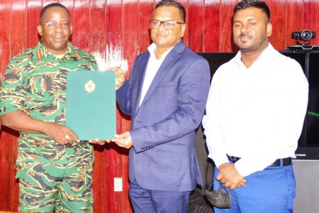GDF Chief of Staff, Brigadier Godfrey Bess (left) with businessman Tamesh Jagmohan (centre) after the signing. (GDF photo)