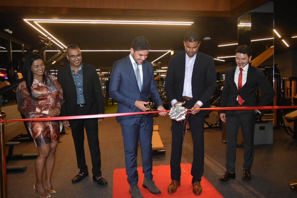 Minister of Sport, Charles Ramson Jr., (right) and Manager, Lucas Mattos ceremoniously cut the ribbon on Sunday to officially commission Space Gym 2.0., the spanking new facility located at the Orchid Garden Hotel and Shopping Mall on Mandela Avenue. 