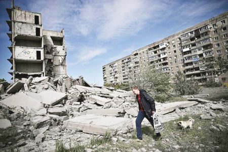 A man walks past a damaged building after a strike in Donbas on May 25, 2022. PHOTO: AFP