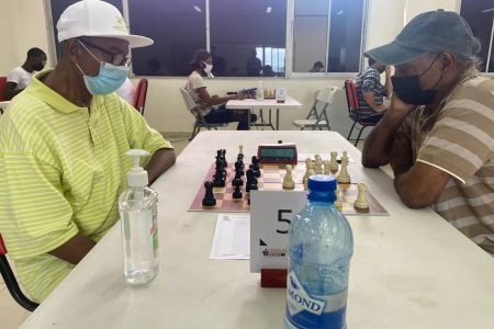 Veteran Stabroek News Columnist Errol Tiwari, left, and old nemesis Rai Sharma battle it out in the second round with Tiwari getting the win. (Photo courtesy of the GCF)