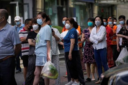 People line up for nucleic acid tests on a street, amid new lockdown measures in parts of the city to curb the coronavirus disease (COVID-19) outbreak in Shanghai, China, June 11, 2022. REUTERS/Aly Song