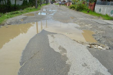 The potholed Lamaha Street, between Middleton and De Abreu streets, Newtown, remains a chore to navigate for many city motorists.  (Photo by Orlando Charles) 