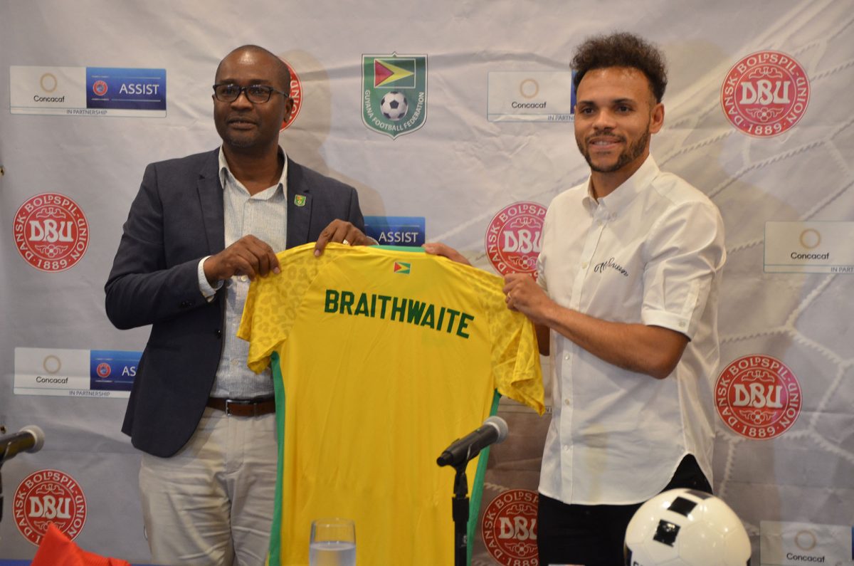 GFF President Wayne Forde (left) gifts Danish and Barcelona forward Martin Brathwaite a Golden Jaguars jersey, following his official unveiling as the Goodwill Ambassador of the DBU 
