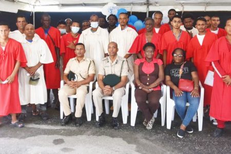 Director of Prisons (ag) Nicklon Elliot (seated second from left) and prison officials pose with some of the inmates who graduated