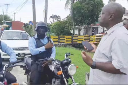 Leader of the Opposition Aubrey Norton questioning the policemen who were trailing him.