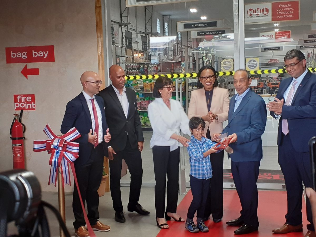 Founder and Executive Chairman of the National Hardware Group of Companies, Edward Boyer (second from right) and Minister of Tourism, Industry and Commerce, Oneidge Walrond (third from right) at the ribbon cutting for the new Super Store yesterday. 