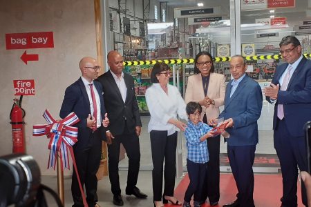 Founder and Executive Chairman of the National Hardware Group of Companies, Edward Boyer (second from right) and Minister of Tourism, Industry and Commerce, Oneidge Walrond (third from right) at the ribbon cutting for the new Super Store yesterday. 