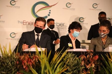 Shell Trinidad and Tobago Limited general manager commercial Stephane Picarle, left, and bpTT president Claire Fitzpatrick both sign documents during the closing of the Trinidad and Tobago deep water competitive bid round 2021/22, at the HYATT Regency, Wrighston Road, Port-of-Spain, on Thursday. Looking on at, right, is Ministry of Energy and Energy Industries Senior State Counsel Louise Pay Wing.