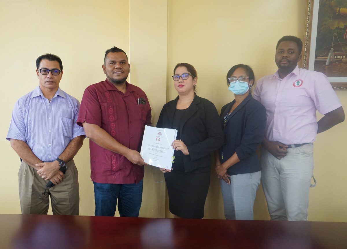 Chief Statistician, Errol La Cruez (second from left) and Senior Operations Manager of Digital Technologies, Jennifer Persaud holding a copy of the contract.  (Bureau of Statistics photo)