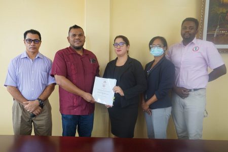 Chief Statistician, Errol La Cruez (second from left) and Senior Operations Manager of Digital Technologies, Jennifer Persaud holding a copy of the contract.  (Bureau of Statistics photo)