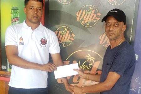 Club member Kacey Pearson (left) receiving the sponsorship cheque from the proprietor of West Vybz Sports Bar Jai Balgobin