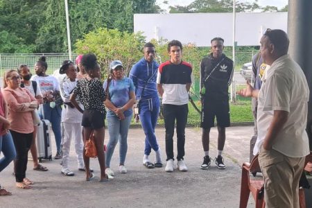 Guyana Amateur Basketball Federation president Mike Singh explains the visa situation to the players and some parents