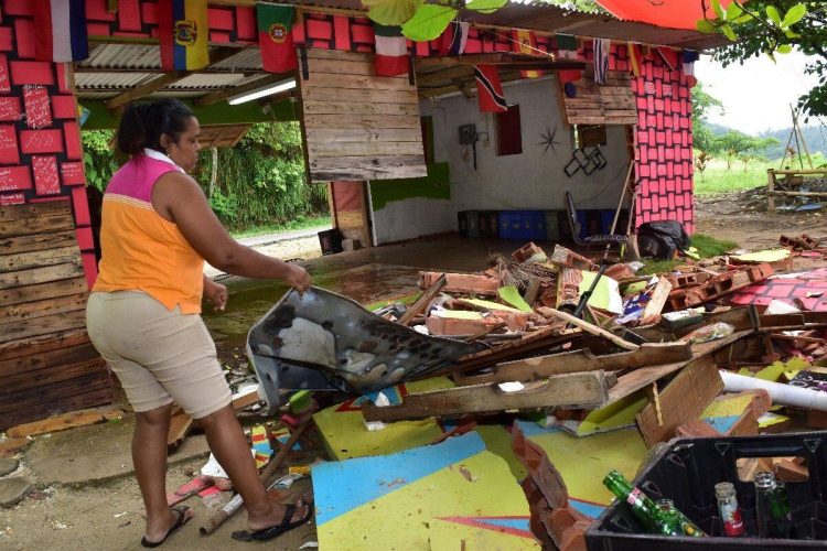 A relative of Darrell John clears debris from the destroyed business yesterday at Tyrico Bay, North Coast Road. —Photo: JERMAINE CRUICKSHANK