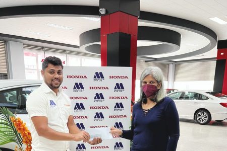 Khemraj Jaikarran, a representative of Marics, hands over the sponsorship cheque to secretary of the Guyana Chess Federation Marcia Lee.